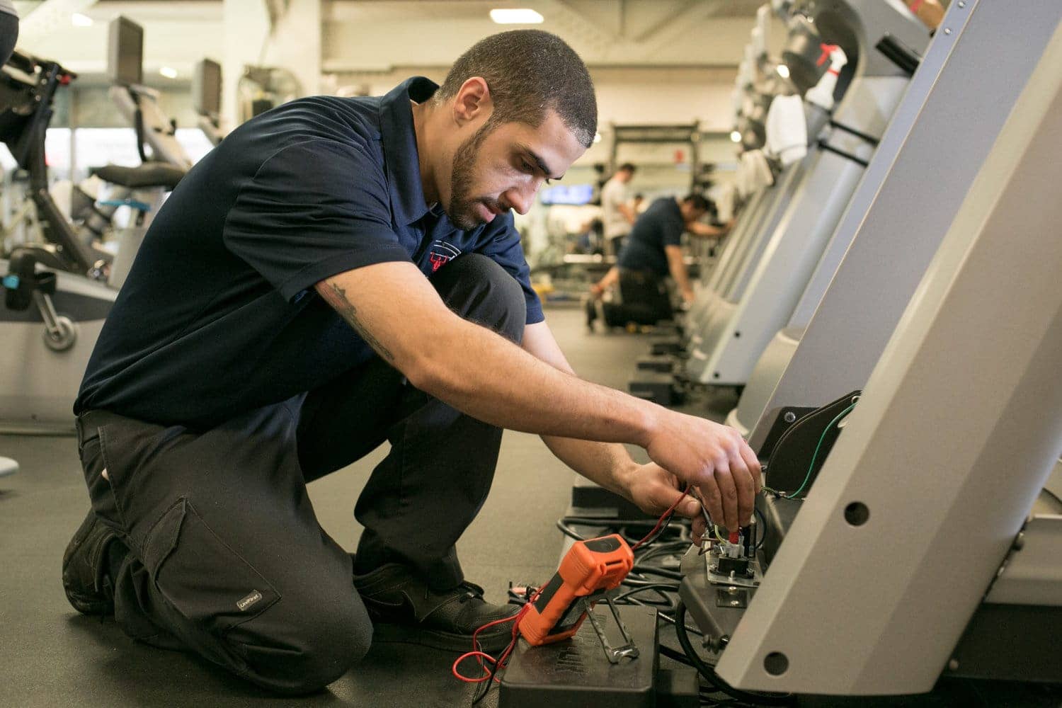 Technician repairing gym equipment